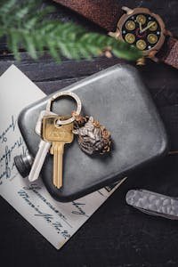 A stylish composition of vintage keys, watch, and metal container on a rustic surface. Perfect for lifestyle themes.